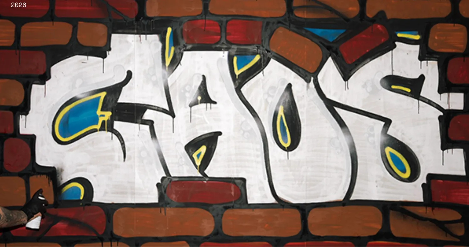 Graffito CAOS su muro di mattoni